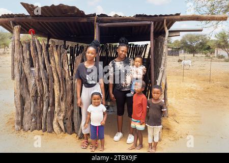 village, famille africaine situé en face de la cabane de cuisine en plein air dans la cour, mère avec des enfants Banque D'Images