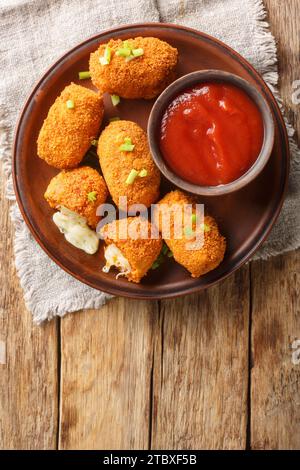 Supli al telefono italien fast food croquettes de riz aux tomates frites farcies de mozzarella closeup sur l'assiette sur la table. Vue verticale de dessus depuis ab Banque D'Images