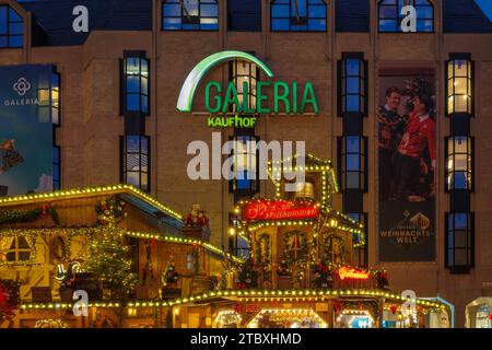 Bonn, Allemagne - 6 décembre 2023 : enseigne lumineuse Galeria Kaufhof, une chaîne de grands magasins allemande, sur l'extérieur d'un bâtiment la nuit encadrée par de la publicité Banque D'Images