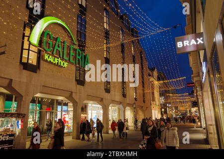 Bonn, Allemagne - 6 décembre 2023 : panneau lumineux Galeria Kaufhof, une chaîne de grands magasins allemande, sur l'extérieur d'un bâtiment la nuit avec des lumières décoratives Banque D'Images