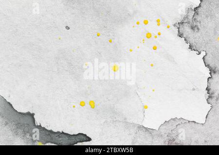 Macro gros plan d'un fond aquarelle gris peint à la main avec des taches d'aquarelle et des gouttes jaunes. Fond de papier texturé avec espace de copie. Banque D'Images