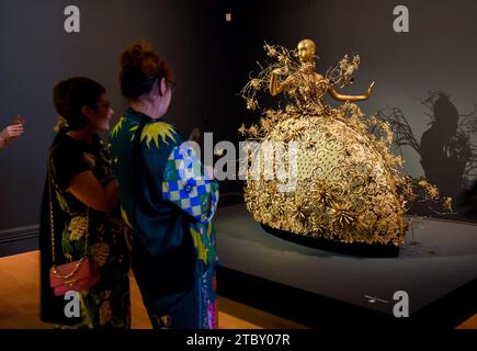 Auckland, Nouvelle-Zélande. 8 décembre 2023. Les visiteurs regardent une création du couturier chinois Guo Pei à Auckland, en Nouvelle-Zélande, le 8 décembre 2023. L'exposition « Fashion, Art, Fantasy » de samedi présentera plus de 60 vêtements saisissants de la carrière de Guo Pei, longue de deux décennies, invitant les Néo-Zélandais à s'immerger dans la grandeur de sa couture artistique. POUR ALLER AVEC 'Feature : l'exposition d'art couture du designer chinois Guo Pei enchante Auckland' crédit : Guo Lei/Xinhua/Alamy Live News Banque D'Images