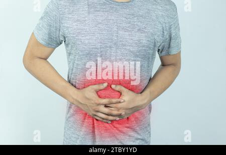 Homme souffrant de douleurs sévères à l'estomac. Main d'un homme mûr tenant l'abdomen souffrant de douleur, de diarrhée ou de problème d'indigestion. Banque D'Images