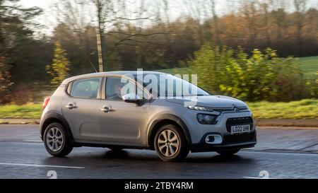 Milton Keynes,Bucks,UK - 8 décembre 2023 : 2022 beige Citroen C3 conduisant sur une route mouillée, sous la pluie avec les phares allumés Banque D'Images