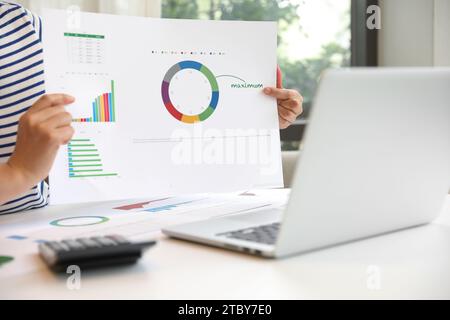 Une femme recommande des produits d'investissement en ligne à l'aide d'un ordinateur portable. Banque D'Images