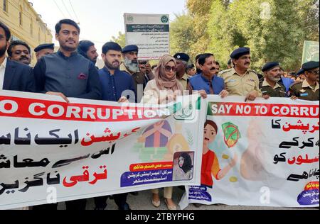 Les participants organisent une marche de sensibilisation contre la corruption organisée par le Département anti-corruption du Sindh, qui se tient à Sukkur le samedi 9 décembre 2023. Banque D'Images