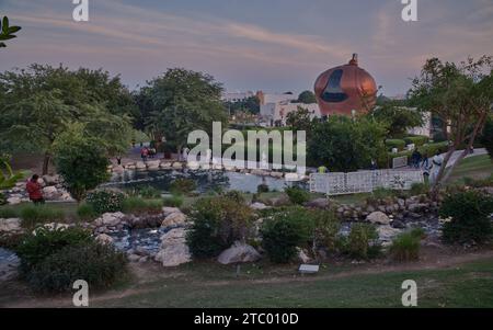 Al-Gannas Qatari Society dans le village culturel Katara Doha, Qatar extérieur coucher de soleil tourné depuis les collines Katara avec cascade au premier plan et horizon Katara Banque D'Images