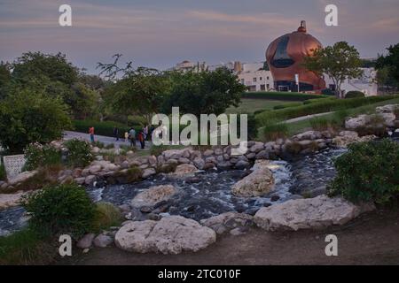 Al-Gannas Qatari Society dans le village culturel Katara Doha, Qatar extérieur coucher de soleil tourné depuis les collines Katara avec cascade au premier plan et horizon Katara Banque D'Images