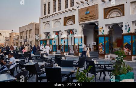 Souq Waqif à Doha, Qatar rue principale après-midi photo montrant le centre d'art Souq Waqif, des restaurants, des gens marchant et le drapeau du Qatar Banque D'Images