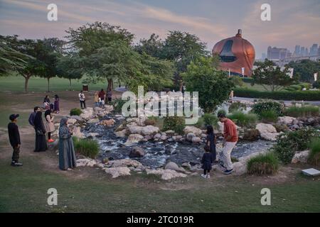 Al-Gannas Qatari Society dans le village culturel Katara Doha, Qatar extérieur coucher de soleil tourné depuis les collines Katara avec cascade au premier plan et horizon Katara Banque D'Images