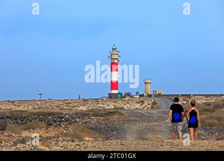 Jeune couple marchant vers le phare, Faro del Tóston Fuerteventura, Îles Canaries, Espagne. Prise en novembre 2023 Banque D'Images