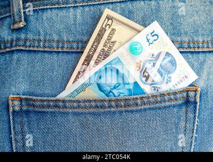 Billet de banque britannique de cinq livres sterling et cinq dollars américains sortant de la poche arrière du Jean pour voyager et faire du shopping Banque D'Images