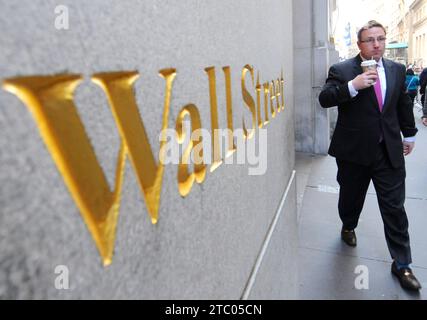 New York, États-Unis - 07 NOVEMBRE 2011. Un homme passe par Wall Street signe-marque-étiquette de la célèbre rue financière de New York, Wall Street. Banque D'Images