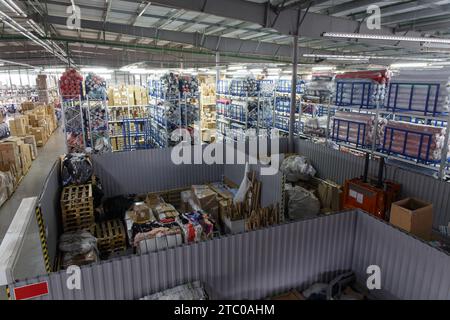 Aperçu d'un grand entrepôt industriel moderne stockant des produits dans des boîtes en carton, des sacs et des rouleaux. Banque D'Images