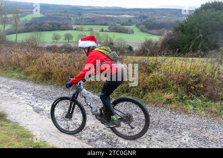 9 décembre 2023. Les concurrents qui font du vélo tout-terrain dans le Dirty Santa MTB Trail cyclable dans les Surrey Hills, en Angleterre, au Royaume-Uni. Beaucoup de cyclistes portaient des costumes de fantaisie sur le thème de Noël, et devenaient très boueux sur la route hors route à travers la région de Surrey Hills de beauté naturelle exceptionnelle. Banque D'Images