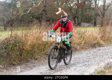 9 décembre 2023. Les concurrents qui font du vélo tout-terrain dans le Dirty Santa MTB Trail cyclable dans les Surrey Hills, en Angleterre, au Royaume-Uni. Beaucoup de cyclistes portaient des costumes de fantaisie sur le thème de Noël, et devenaient très boueux sur la route hors route à travers la région de Surrey Hills de beauté naturelle exceptionnelle. Banque D'Images