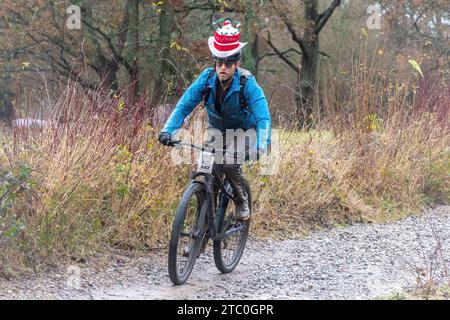 9 décembre 2023. Les concurrents qui font du vélo tout-terrain dans le Dirty Santa MTB Trail cyclable dans les Surrey Hills, en Angleterre, au Royaume-Uni. Beaucoup de cyclistes portaient des costumes de fantaisie sur le thème de Noël, et devenaient très boueux sur la route hors route à travers la région de Surrey Hills de beauté naturelle exceptionnelle. Banque D'Images