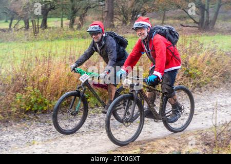 9 décembre 2023. Les concurrents qui font du vélo tout-terrain dans le Dirty Santa MTB Trail cyclable dans les Surrey Hills, en Angleterre, au Royaume-Uni. Beaucoup de cyclistes portaient des costumes de fantaisie sur le thème de Noël, et devenaient très boueux sur la route hors route à travers la région de Surrey Hills de beauté naturelle exceptionnelle. Banque D'Images