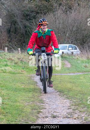 9 décembre 2023. Les concurrents qui font du vélo tout-terrain dans le Dirty Santa MTB Trail cyclable dans les Surrey Hills, en Angleterre, au Royaume-Uni. Beaucoup de cyclistes portaient des costumes de fantaisie sur le thème de Noël, et devenaient très boueux sur la route hors route à travers la région de Surrey Hills de beauté naturelle exceptionnelle. Banque D'Images