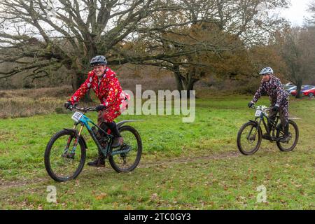 9 décembre 2023. Les concurrents qui font du vélo tout-terrain dans le Dirty Santa MTB Trail cyclable dans les Surrey Hills, en Angleterre, au Royaume-Uni. Beaucoup de cyclistes portaient des costumes de fantaisie sur le thème de Noël, et devenaient très boueux sur la route hors route à travers la région de Surrey Hills de beauté naturelle exceptionnelle. Banque D'Images