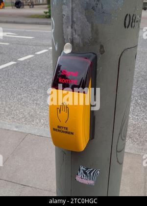 Boîte de signalisation pour les personnes à toucher sur un passage pour piétons (signal kommet. Bitte beruhren traduit « le signal arrive. Veuillez toucher.'), Hambourg, Allemagne. Banque D'Images