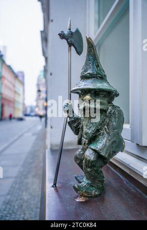 Wrocław, pologne - 08 décembre 2023 : l'emblématique nain de Wrocław nommé Strażnik assis sur un alambic de fenêtre Banque D'Images