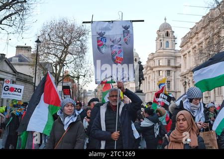 Londres, Royaume-Uni. 9 décembre 2023. Un manifestant tient une pancarte avec des noms de marques liées à Israël. Des dizaines de milliers de personnes défilent de la ville de Londres à la place du Parlement pour appeler à un cessez-le-feu permanent à Gaza alors que la guerre Israël-Hamas passe deux mois plus tard. Crédit : Photographie de onzième heure / Alamy Live News Banque D'Images