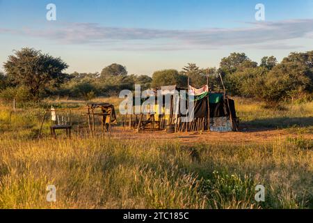 cabane sur le bord de la route dans la brousse, typique installation informelle afrique Banque D'Images