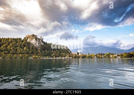 Vue panoramique sur le lac de Bled en Slovénie, en Europe et ses environs avec le château de Bled debout sur la falaise rocheuse au-dessus du lac Banque D'Images