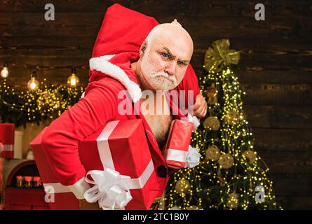 Sécurité de Noël contre les cambrioleurs et sécurité à domicile. Scène de crime de vacances. Père Noël dans le masque avec sac. Home Burglar Santa Claus dans un masque dans la maison. Banque D'Images