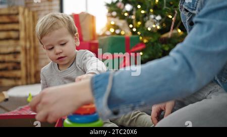 Père et fils célébrant noël en jouant avec des jouets à la maison Banque D'Images