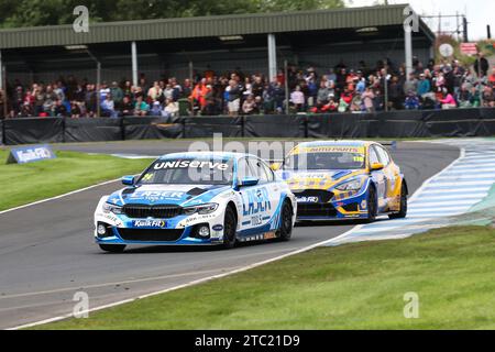 24 Jake Hill MB Motorsport avec laser Tools BMW 330i et 116 Ash Sutton Napa Racing Ford Focus se battent pour la victoire Banque D'Images