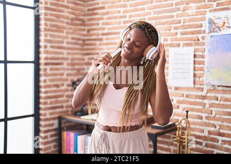 Femme afro-américaine écoutant de la musique chantant à la maison Banque D'Images