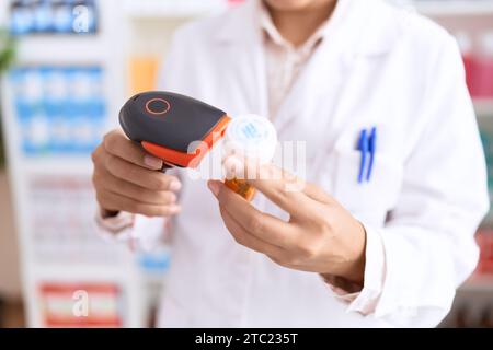 Jeune femme arabe pharmacien balayage pilules bouteille à la pharmacie Banque D'Images