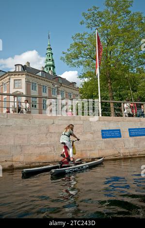 Femme faisant du vélo d'eau dans un canal, Copenhague, Danemark Banque D'Images