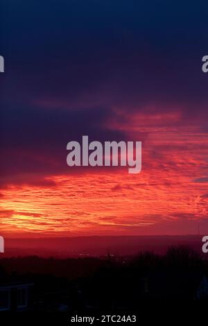 West Yorkshire, Royaume-Uni. 10 décembre 2023. UK Météo. Northowram, West Yorkshire, Royaume-Uni. Un magnifique lever de soleil après la tempête Elin sur les Pennines vu du village de Northowram près de Halifax, West Yorkshire avec l'émetteur classé Grade 2 de Emley Moor sur la ligne d'horizon. Crédit : Windmill Images/Alamy Live News Banque D'Images