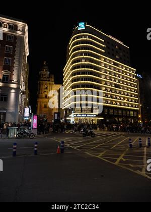 Málaga, Espagne - 8 décembre 2023 : vue de l'Hôtel AC Málaga Palacio avec des lumières de Noël et la cathédrale. Banque D'Images