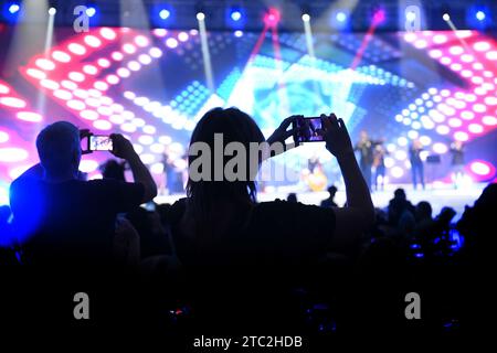 filmez un spectacle avec un téléphone portable dans la salle de concert. Avec musique et lumière de scène Banque D'Images