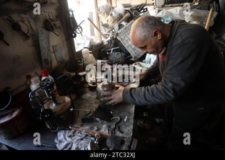 Khan Yunis, Gaza. 08 décembre 2023. Un réparateur Hold répare des fourneaux à pression à kérosène dans son atelier de Rafah, dans le sud de la bande de Gaza, le 9 décembre 2023, alors que les Palestiniens recourent aux alternatives les moins chères disponibles pour cuisiner et se chauffer dans un contexte de pénurie de ressources alors que les combats se poursuivent entre Israël et les militants palestiniens dans la bande de Gaza. Photo par Ismael Mohamad/UPI. Crédit : UPI/Alamy Live News Banque D'Images