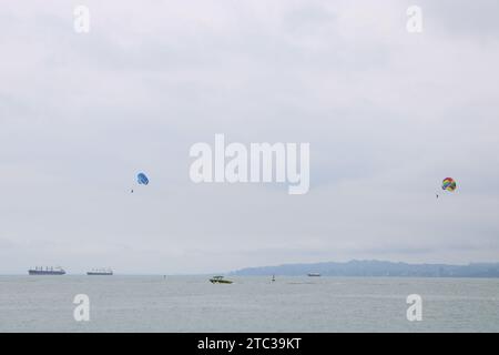 bateaux flottant sur la mer et personnes parapente dans le ciel. batumi géorgie. Banque D'Images