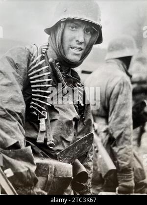 BATAILLE DU BULBE du 16 décembre 1944 au 28 janvier 1945. Toujours d'un film allemand montrant un soldat lourdement armé portant une plaque de mortier dans la région des Ardennes en Belgique Banque D'Images