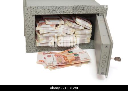 Petit coffre-fort à la maison plein de paquets de roubles russes en 5000 billets de banque, isolé sur un fond blanc Banque D'Images