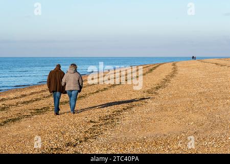 Les gens marchent le long de la rive du Wash dans l'ouest du Norfolk le jour de l'hiver. Banque D'Images