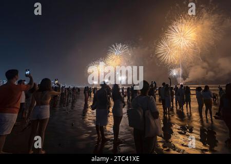 Santos City, Brésil. Feux d'artifice sur la plage. Les gens qui prennent des photos avec des téléphones portables et regardent des feux d'artifice pendant la nouvelle année Banque D'Images