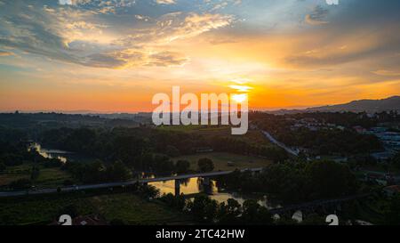Un soleil se couche dans une scène pittoresque sur un lac tranquille, créant un coucher de soleil magnifique qui est sûr de vous couper le souffle Banque D'Images
