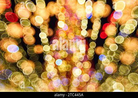 Noël et bonne année bokeh flou. Photo authentique de lumière colorée sur un arbre de noël en plein air avec bokeh. Magnifique arrière-groun bokeh de noël Banque D'Images