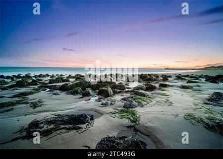 Plage de sable avec de grandes pierres à l'aube le long de la côte de Walcheren dans la province de Zeeland, aux pays-Bas Banque D'Images