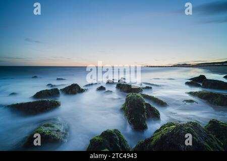 Plage de sable avec de grandes pierres à l'aube le long de la côte de Walcheren dans la province de Zeeland, aux pays-Bas Banque D'Images