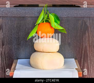 Décoration traditionnelle japonaise du nouvel an Kagami Mochi avec deux gâteaux de riz empilés recouverts d'une orange amère Daidai avec des feuilles attachées qui est un n Banque D'Images