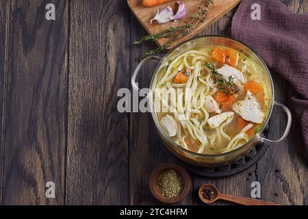 Nouilles bouillies avec du poulet dans une casserole sur la table avec espace de copie, vue de dessus Banque D'Images